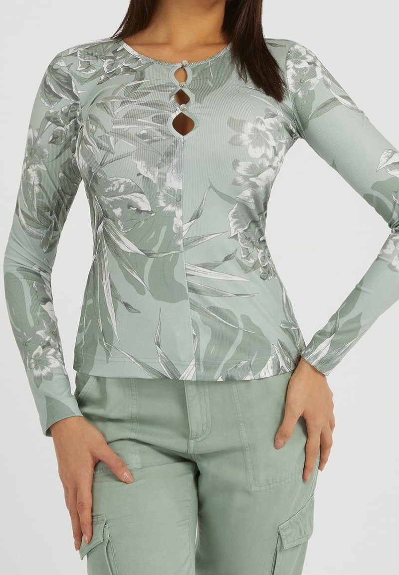 Haut à manches longues vert menthe avec motif floral, texture côtelée, détail de bouton en forme de goutte à l'encolure, assorti à un pantalon cargo vert assorti.