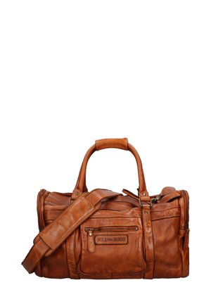 Sac de voyage en cuir marron avec des poignées doubles et une bandoulière amovible. Présente plusieurs poches zippées et une surface texturée.
