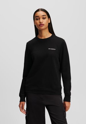 Schwarzer Sweatshirt mit Rundhalsausschnitt, langen Ärmeln und gerippten Bündchen. Verfügt über ein kleines weißes "KARL LAGERFELD"-Logo auf der Brust.