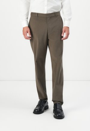 Trousers in olive green, featuring a flat front, straight leg design, belt loops, and soft fabric. Paired with black loafers.