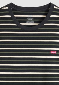 Černé a krémové tričko s olivově zelenými pruhy. Má kulatý výstřih a malé červené logo Levi's na levé straně. Materiál je směs bavlny.