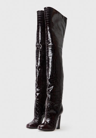 Knæhøje, blanke, mørkebrune støvler med krokodillestruktur og høje stiletthoer, der har en tætsiddende design og spidse tåer.
