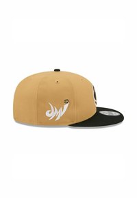 Casquette de baseball jaune avec une visière noire. Présente un texte blanc brodé et une icône de basketball sur le côté. Design classique ajusté.