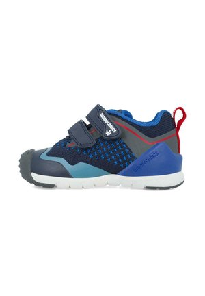 Zapato infantil azul y marino con parte superior de malla, dos correas de velcro, tapa de goma en la punta y acentos contrastantes en gris y rojo. Diseño ligero.