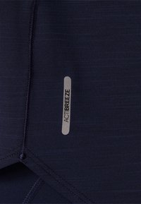 Tkanina sportowa w granatowym kolorze o gładkiej fakturze, ze szwami płaskimi i przyszytą srebrną etykietą "ACTIBREEZE".