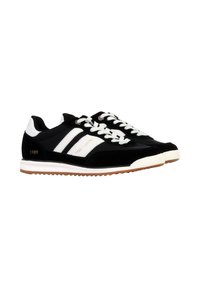 Sneaker in suede nero con strisce bianche, lacci bianchi e suola in gomma color gomma. Presentano un logo dorato e l'anno "1989" sul lato.