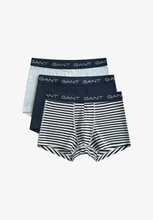 Trois paires de boxers pour hommes avec ceintures à logo GANT, comprenant un modèle uni bleu marine, un rayé bleu clair, et un rayé horizontal bleu marine et blanc.