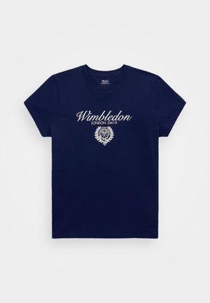 Jūras zila kokvilnas T-krekls ar īsām piedurknēm, ar baltu tekstu "Wimbledon LONDON SW19" un dekoratīvu simbolu ar lauru zariem.