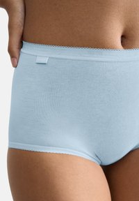Slip in cotone azzurro chiaro con delicati bordi in pizzo nella parte superiore e un piccolo etichetta, caratterizzato da una texture liscia e un design aderente.