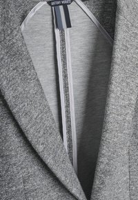 Blazer grigio con una consistenza morbida, rever a punta e fodera interna grigia chiara. L'etichetta recita "ANTONY MORATO" sul colletto.