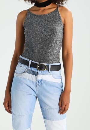 Body de manga corta metálico gris combinado con jeans de parches azul claro, con un cinturón negro con hebilla redonda.