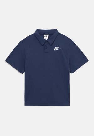 Tumesinine lühikeste varrukatega polo särk kahe nupu ja vasakul rinnal oleva valge Nike logoga heleda taustaga.