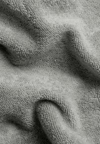 Gray towel with a textured, looped weave, featuring soft, plush fibers that create a wrinkled appearance.