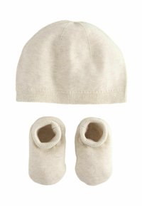 Bonnet en tricot beige avec une couronne ronde et un ourlet côtelé, associé à des chaussons doux assortis dotés d'ouvertures élastiques. Léger et chaud.