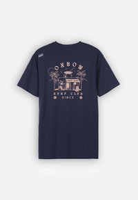 T-shirt en coton bleu marine avec un graphisme rose représentant un club de surf avec des palmiers, du texte et un petit logo sur l'épaule. Manches courtes et col rond.