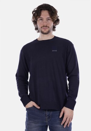 Maglione blu navy a maniche lunghe realizzato in morbido tessuto a maglia, con colletto e polsini a coste e un piccolo logo sul petto.