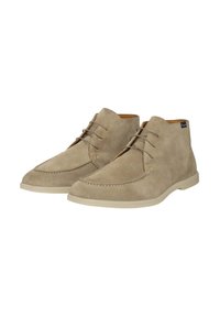 Botas de tobillo de ante beige con puntera redonda, que presentan cierre con cordones y suela de goma ligera en contraste. Detalles de costura alrededor de la puntera.
