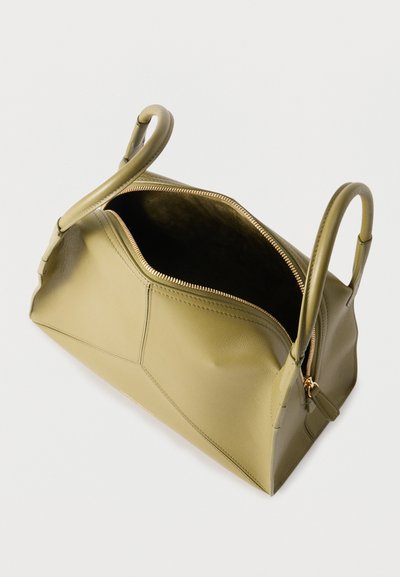 Τσάντα χειρός από δέρμα σε ελιά πράσινο με επάνω φερμουάρ μερικώς ανοιχτό και δύο κυλινδρικές λαβές, εμφανιζόμενη με φόντο λευκό.