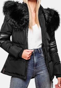 Sort polstret jakke med faux fur detaljer på hætten, lynlås foran, ribbede manchetter og sidelommer. Stylet med en hvid top og denim jeans.