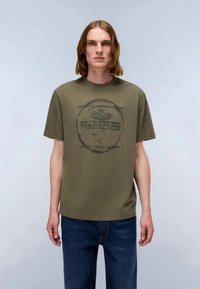 Ελαιόχρωμο βαμβακερό T-shirt με στρογγυλή λαιμόκοψη, κοντά μανίκια και κυκλική εκτύπωση γραφικών στο στήθος που απεικονίζει κείμενο και μια ελέφαντα.