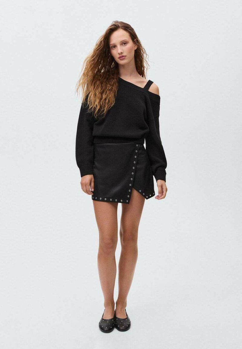 Črna off-shoulder pulover, z rebrastimi manšetami, v kombinaciji s črno usnjeno mini krilom z gumbi na strani. Črne balerinke s konicami.