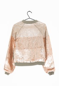 Bundi s flitry s dvoubarevným designem; horní polovina ve zlatých flitrech a spodní polovina v růžovém zlatě. Obsahuje zelený žebrovaný límec a manžety.