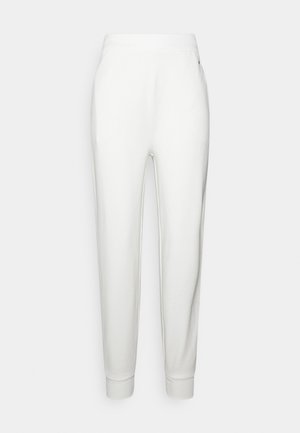 Pantalon de survêtement blanc effilé avec ceinture et poignets élastiques, vue de face sur un fond clair uni.