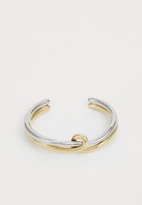 Pulsera de pulsera de metal que presenta bandas entrelazadas de plata y oro con un acabado suave y pulido. Detalle de nudo notable en el centro.