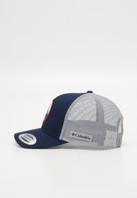Marineblå baseballcaps med grå mesh-bak, flat skjerm og et sirkulært logo-lapp foran; Columbia-logo på siden.