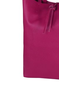 Sac fourre-tout en cuir magenta avec une finition texturée, doté d'une fermeture à cordon de serrage et de deux bretelles pour un port facile.