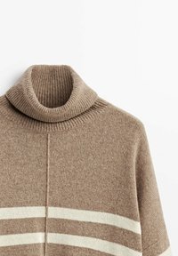 Beżowy sweter z golfem wykonany z dzianiny, z prążkowanym kołnierzem, z dwoma poziomymi białymi paskami i miękką fakturą.