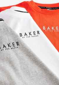 Trzy koszulki w kolorach pomarańczowym, białym i szarym, wykonane z bawełny. Każda koszulka ma nadruk "BAKER BY TED BAKER" w kolorze czarnym. Miękka faktura, fason z okrągłym dekoltem.