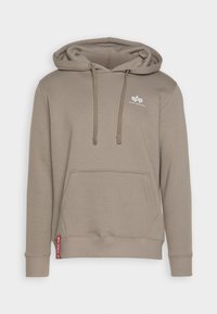 Barna kapucnis pulóver elülső zsebbel, állítható húzózsinórral és logóval a mellrészen. Bordás mandzsettákkal és heméllyel rendelkezik a szoros illeszkedés érdekében.