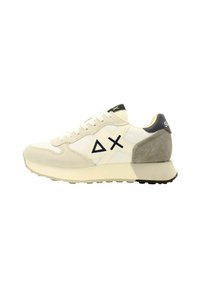 Baskets blanches et beiges avec un talon en daim, un panneau texturé, un design à lacets et des accents de logo noirs sur le côté et le talon.