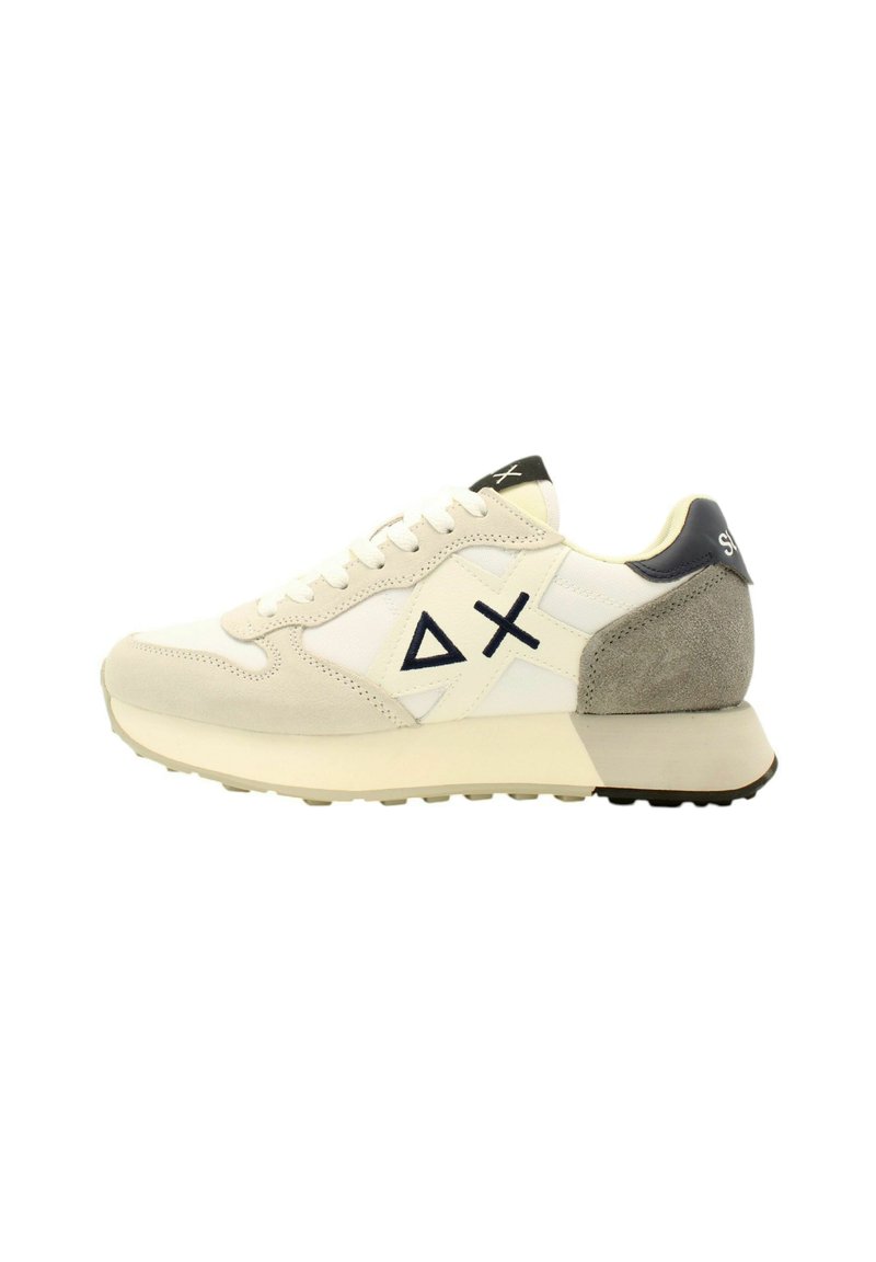 Baskets blanches et beiges avec un talon en daim, un panneau texturé, un design à lacets et des accents de logo noirs sur le côté et le talon.