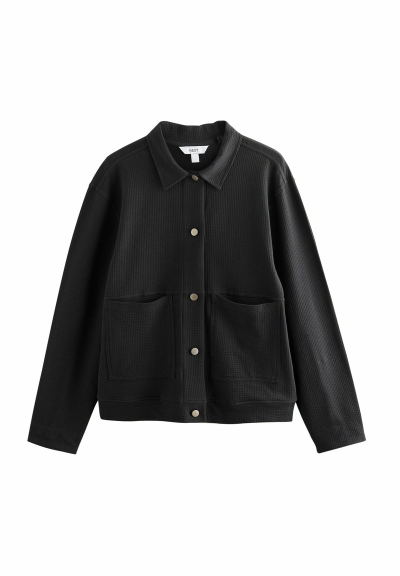 Veste noire à manches longues avec boutons, col large et deux poches plaquées devant, en tissu texturé.