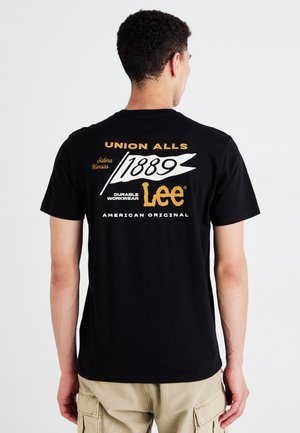T-shirt in cotone nero con testo audace in bianco e oro. Design distintivo include "LEe," "1889," e "UNION ALLS," con una finitura liscia.