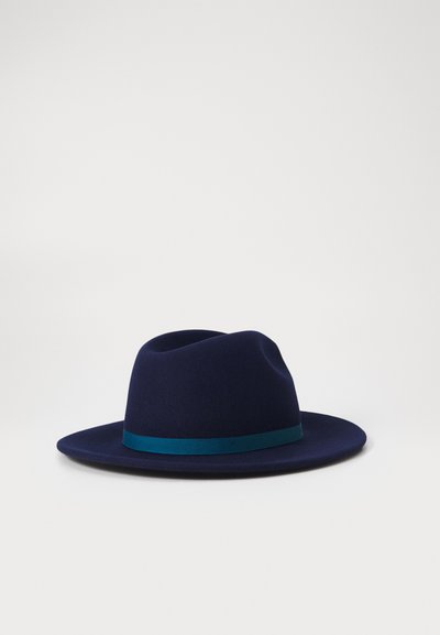 Navy wool hat with a wide brim and a teal ribbon band. The design features a soft crown and smooth texture. Minimalist and structured shape.