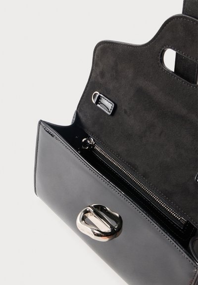 Μαύρη δερμάτινη τσάντα με ανοιχτό καπάκι που αποκαλύπτει το μαύρο σαμουά εσωτερικό και τσέπη με ασημένιο φερμουάρ, ασημένια αγκράφα στο μπροστινό μέρος.