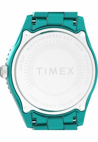 Turkusowy zegarek ze stali nierdzewnej z gładką okrągłą kopertą, teksturowaną koronką i białą tarczą z napisem "TIMEX" oraz wzorem w kształcie promieni słońca.