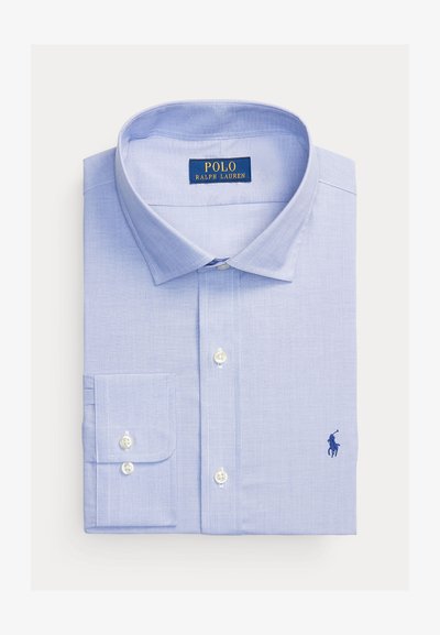 Lys blå skjorte med knapper laget av vevd stoff, med nedbrettet krage, en enkelt brystlomme, og en brodert logo i mørk blå.