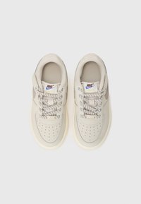 Baskets en cuir beige avec des lacets à motifs, accents gris et bout perforé. Présentent un design classique et une semelle en caoutchouc.