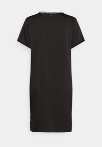 Černé šaty s krátkým rukávem, které mají kulatý výstřih a kontrastní vzorovaný lem na zádech. Hladká tkanina se rovnou siluetou.