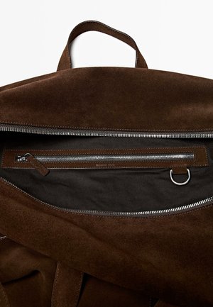 Borsa in suede marrone con forma solida; presenta un'ampia apertura con cerniera, tasca interna con zip e dettagli in pelle. Interno strutturato.