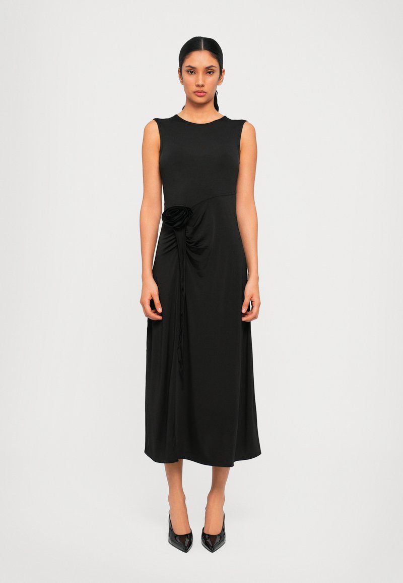 Svart ärmlös klänning med en figursydd bodice och draperad midjedetalj som har en blommig accent. Midi-längd med en mjuk struktur.
