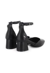 Zapatos de mujer de cuero negro con tacón cuadrado y correas en el tobillo, con cierres de hebilla plateada, que presentan un logotipo "bg" en la parte trasera.