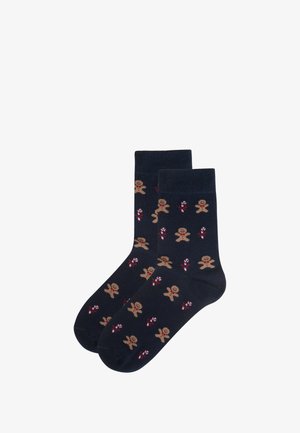 Navy socks featuring a repeated pattern of gingerbread men and candy canes, knit texture, mid-calf length, and reinforced toe and heel.