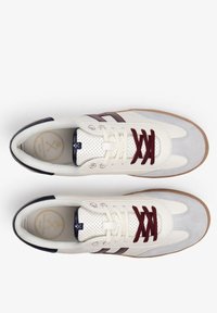 Zapatillas con parte superior de cuero blanco y ante gris, acentos en granate y azul marino, detalles perforados y suela de goma marrón.