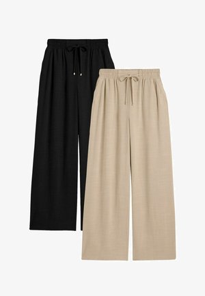 Pantalones de pierna ancha en negro y beige con cintura elástica y cordón, con bolsillos laterales y un ajuste relajado.