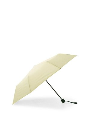 Beżowy kompaktowy parasol z czarną rączką i paskiem na nadgarstek, otwarty i przechylony pod kątem na białym tle.